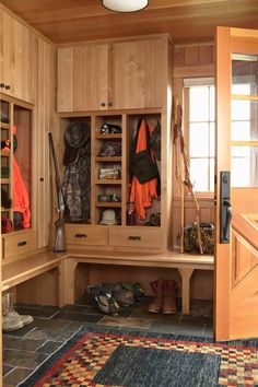 the inside of a wooden closet filled with lots of shoes and coats on it's shelves