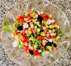 a glass bowl filled with salad on top of a table