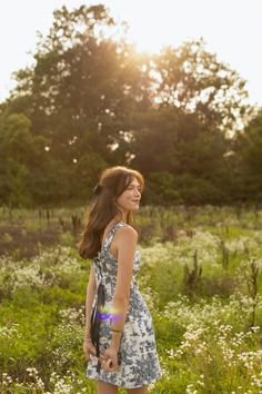 a woman standing in the middle of a field