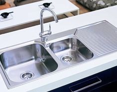 a kitchen sink with two faucets in it