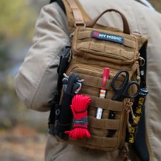 a man carrying a back pack with many items attached to it's back pocket