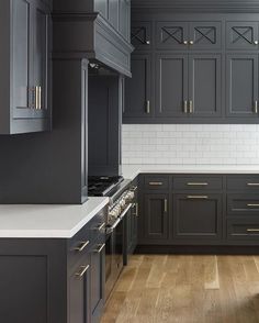 an empty kitchen with gray cabinets and white counter tops