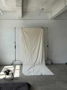 an empty photo studio with a white backdrop and lighting equipment in the foreground,