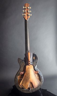 an old guitar sitting on top of a black cloth