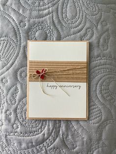 an anniversary card with a ribbon on top of it and the words happy anniversary written in cursive writing