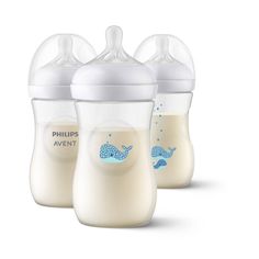 three baby bottles with blue whale designs on the top one is empty and the other has no lid