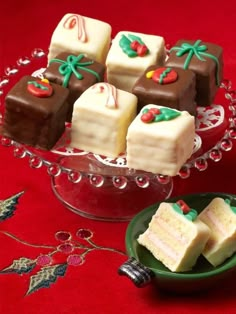 several pieces of cake sitting on a glass plate next to a bowl with other desserts in it