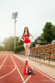 a cheerleader standing on top of a red cone