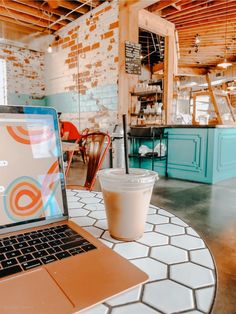 an open laptop computer sitting on top of a table next to a cup of coffee