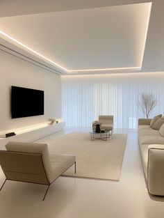 a modern living room with white walls and flooring is lit by recessed lighting