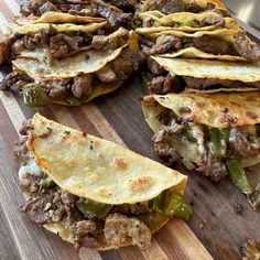 a wooden cutting board topped with tacos and tortillas