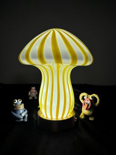 a lamp that is sitting on a table next to some toy figurines in front of it