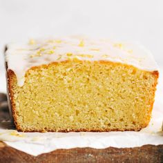 a close up of a slice of cake with icing on a piece of wood