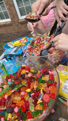 several people are eating gummy bears out of a bowl