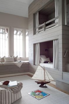 a living room filled with furniture and a white ship on top of the fireplace mantel