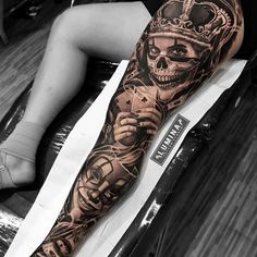 a man with a tattoo on his arm and leg is sitting in front of a table