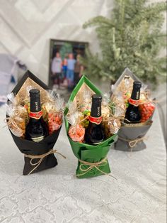 three wine bottles wrapped in paper and tied with twine on top of a table