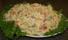 a white plate topped with salad and lettuce on top of a black counter