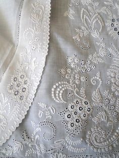 an embroidered white fabric with black and white flowers