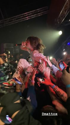 a woman is on top of a man's shoulders at a concert