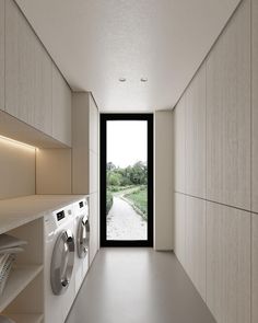 an empty laundry room with washer and dryer in the hallway next to it