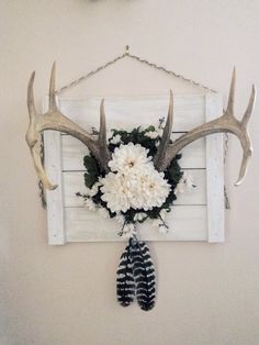 the antlers are hanging on the wall with flowers