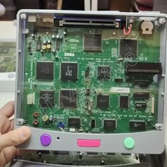 the inside of a computer motherboard being held up by someone's hand