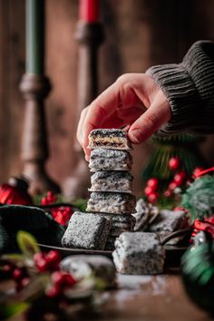 a person stacking cookies on top of each other in front of some christmas decorations