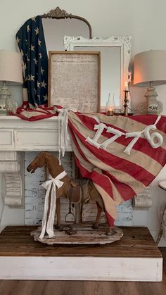 an american flag draped over a horse statue in front of a fireplace mantel and mirror