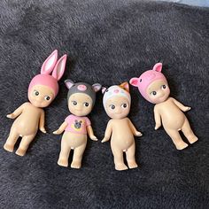 five little dolls are laying on a black blanket