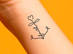 a small tattoo on the arm of a woman's wrist that says, love