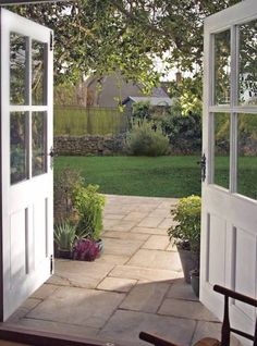 an open door leading to a lush green yard