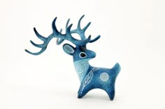 a blue ceramic deer figurine with antlers on it's head, against a white background