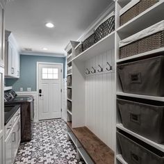 a walk - in closet with lots of drawers and baskets on the shelves next to it