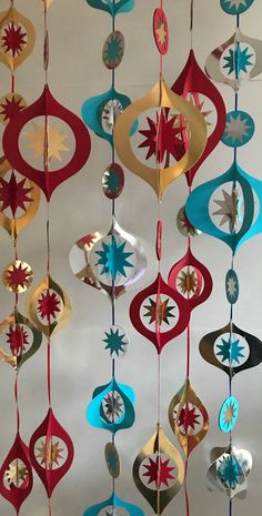 a group of ornaments hanging from a ceiling in the shape of stars and circles on strings