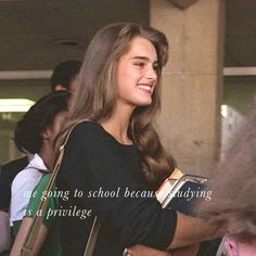 a girl is smiling and holding a book