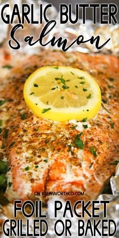 garlic butter salmon on foil with lemon wedges