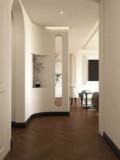 an empty room with white walls and wood floors, along with a large mirror on the wall