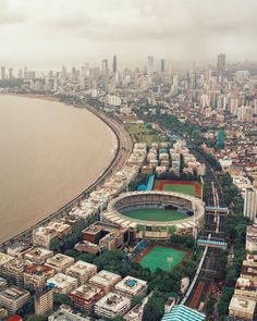 an aerial view of a baseball stadium in the middle of a city with lots of tall buildings