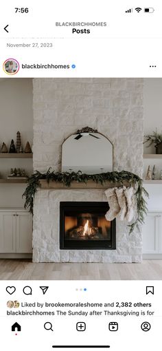 the fireplace is decorated with greenery and stockings