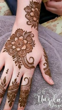 a woman's hand with henna tattoos on it