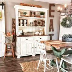 a dining room table with chairs and a hutch in the backround area