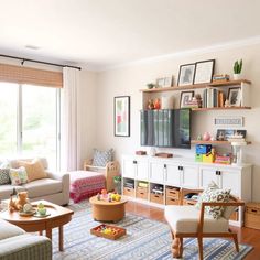 a living room filled with furniture and a flat screen tv on top of a wooden shelf