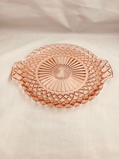 a pink glass dish sitting on top of a white table