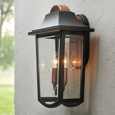 two lights are attached to the side of a wall mounted light on a house's exterior