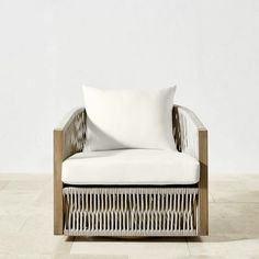 a white chair sitting on top of a tile floor next to a wall with a wooden frame