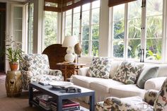 a living room filled with furniture and lots of windows