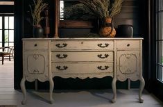 an old dresser with flowers and plants on top