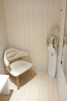 a white chair sitting in a bathroom next to a shower