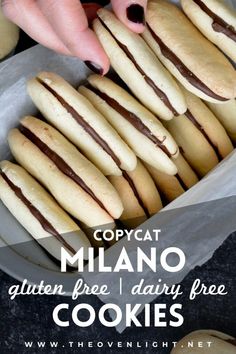 there are many cookies in the pan with chocolate frosting on them and one is being dunked